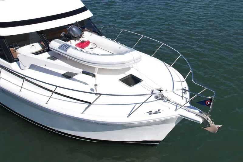 Slide: The Image of 1998 Riviera 43 Open Flybridge yacht with inflatable boat on deck, anchored in calm waters. - 10