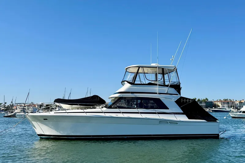 Slide: The Image of 1998 Riviera 43 Open Flybridge yacht on calm water, clear blue sky background. - 12