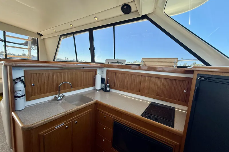 Slide: The Image of Interior of 1998 Riviera 43 Open Flybridge yacht kitchen with wooden cabinets and appliances. - 16