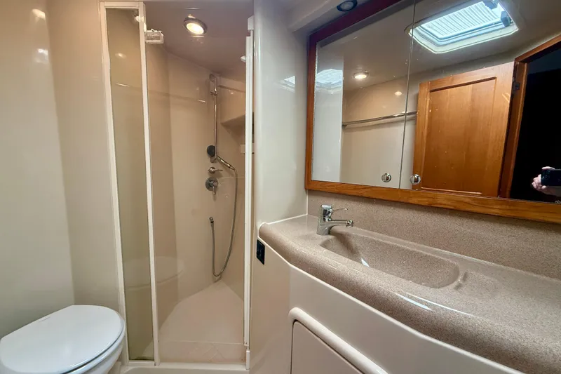Slide: The Image of Bathroom interior of 1998 Riviera 43 Open Flybridge yacht, featuring shower, sink, and mirror. - 36
