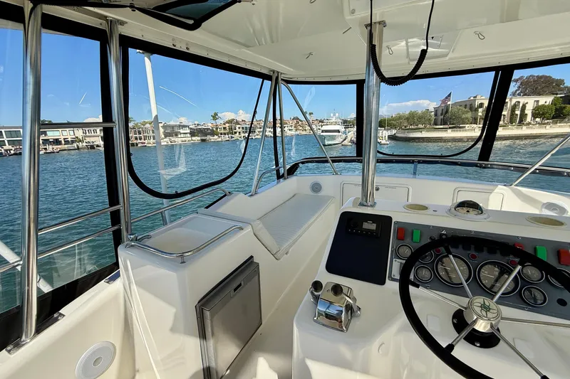 Slide: The Image of 1998 Riviera 43 Open Flybridge helm with waterfront view, showcasing controls and seating. - 46