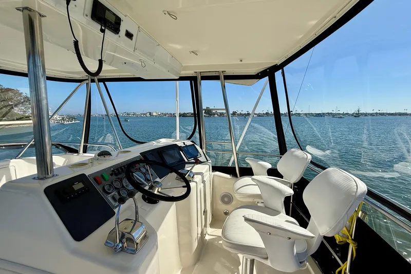 Slide: The Image of 1998 Riviera 43 Open Flybridge helm with ocean view, featuring modern controls and seating. - 47