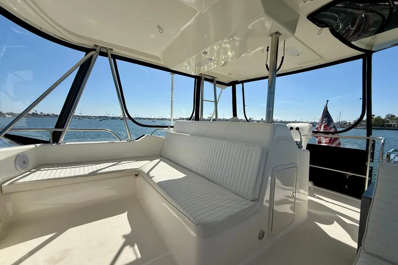 Slide: The Image of 1998 Riviera 43 Open Flybridge interior with seating, overlooking a scenic waterfront view. - 52