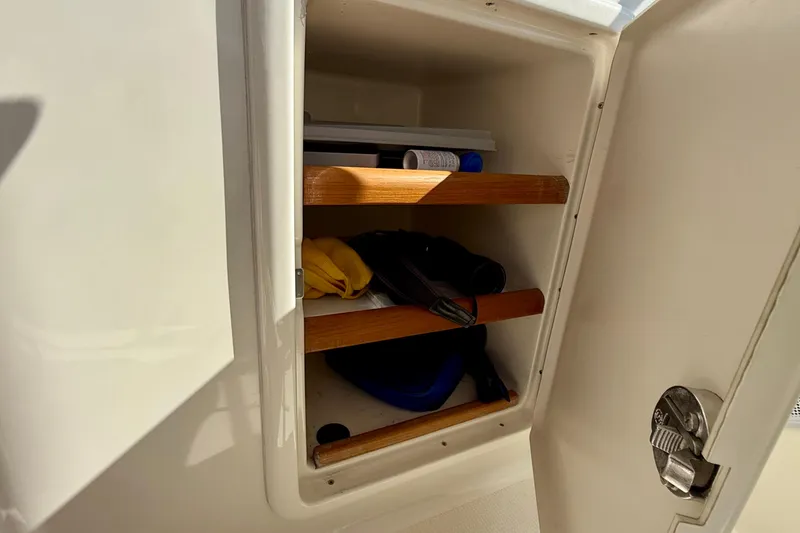 Slide: The Image of Storage compartment on a 1998 Riviera 43 Open Flybridge boat with shelves and items. - 53