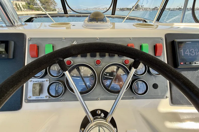 Slide: The Image of Steering wheel and dashboard of 1998 Riviera 43 Open Flybridge yacht, featuring gauges and controls. - 56