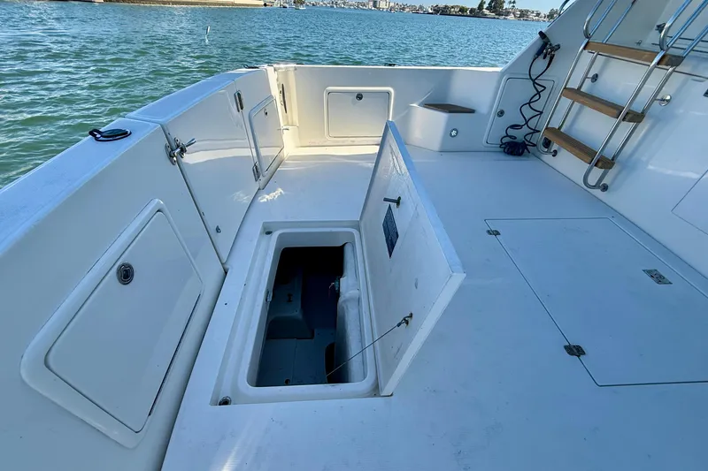 Slide: The Image of 1998 Riviera 43 Open Flybridge boat deck with open storage compartment and ladder. - 71