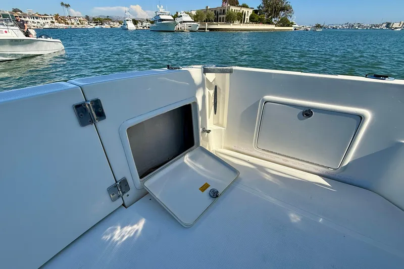 Slide: The Image of 1998 Riviera 43 Open Flybridge boat deck with storage compartments, docked in a scenic marina. - 72