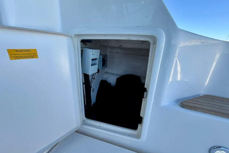 Slide: The Image of Access hatch on 1998 Riviera 43 Open Flybridge, showing interior compartment and warning label. - 73