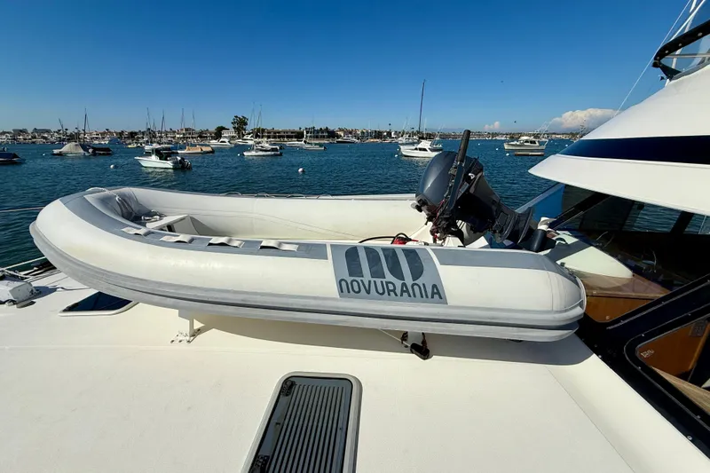 Slide: The Image of Riviera 43 Open Flybridge 1998 with Novurania tender on deck, moored in a scenic harbor. - 75