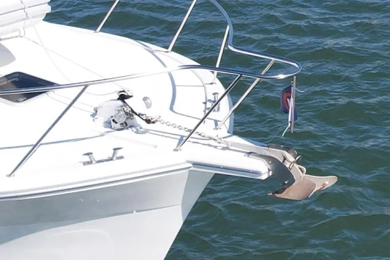 Slide: The Image of 1998 Riviera 43 Open Flybridge yacht bow with anchor and railing on water. - 9