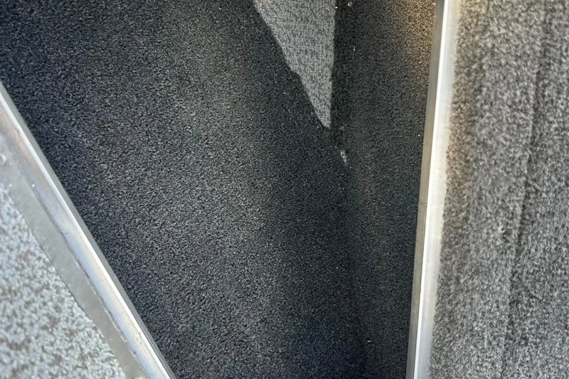 Slide: The Image of Interior view of 2026 Lund 1975 Tyee boat with dark carpet flooring. - 11