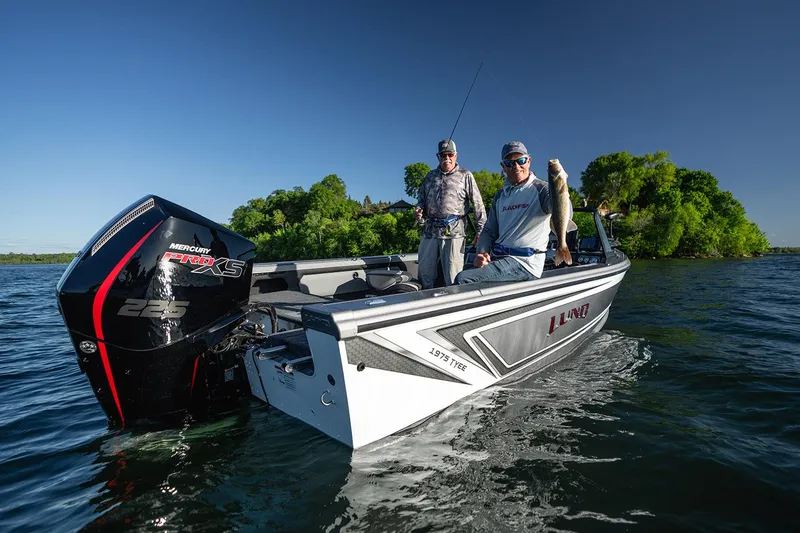Slide: The Image of 2026 Lund 1975 Tyee boat on trailer at Premier Boating Center, under cloudy sky. - 2