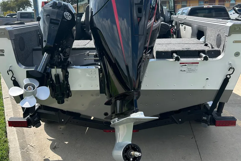 Slide: The Image of 2026 Lund 1975 Tyee boat with dual outboard motors, parked on a trailer. - 20