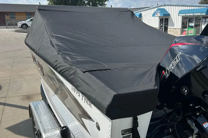 Slide: The Image of Covered 2026 Lund 1975 Tyee boat with motor at a boating center. - 22