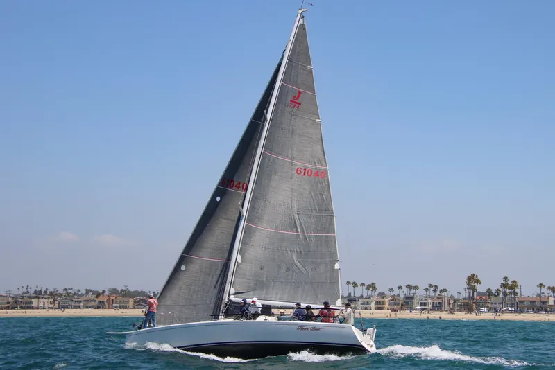 Slide: The Image of 2007 J Boats J/124 sailing near a coastal city with clear skies. - 1