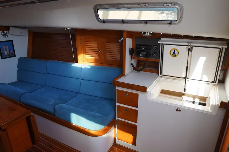 Slide: The Image of Interior of 2007 J Boats J/124 sailboat with blue seating and wooden cabinetry. - 11