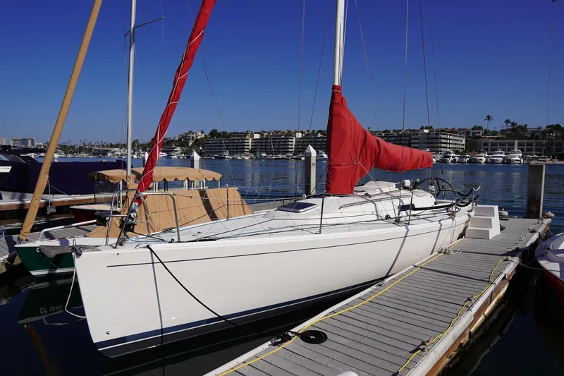 Slide: The Image of 2007 J Boats J/124 sailboat docked with red sail cover, clear blue sky. - 2