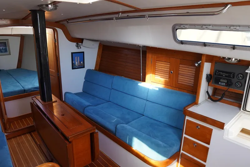 Slide: The Image of Interior of 2007 J Boats J/124 sailboat with blue seating and wooden cabinetry. - 6
