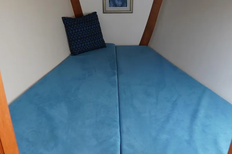 Slide: The Image of Interior cabin of 2007 J Boats J/124 with blue bedding and decorative pillow. - 8