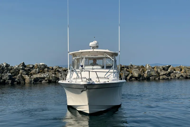Slide: The Image of 2008 Grady White Express boat on calm water near rocky shoreline. - 2