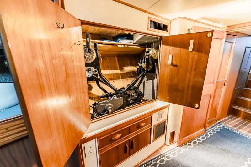 Slide: The Image of Interior of 1988 Buddy Davis 47 Convertible yacht showing open wooden cabinet with mechanical components. - 58