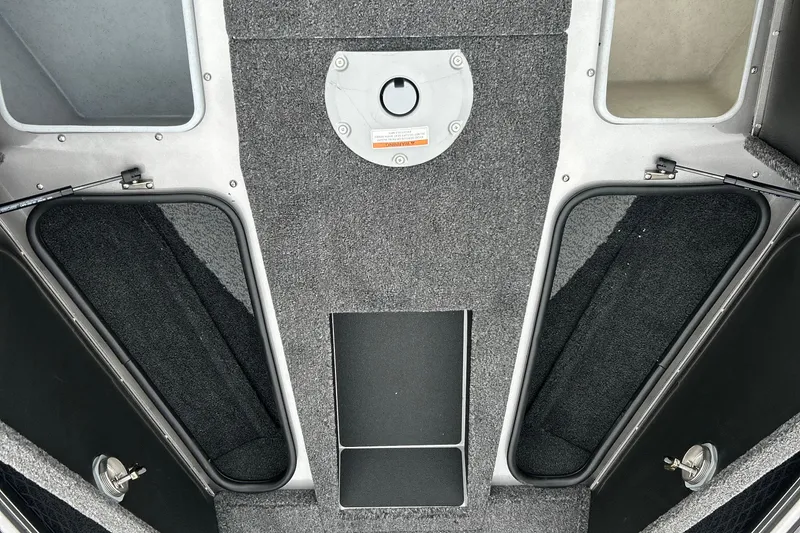 Slide: The Image of Interior view of 2026 Lund 1975 Pro-V boat, featuring storage compartments and carpeted flooring. - 23