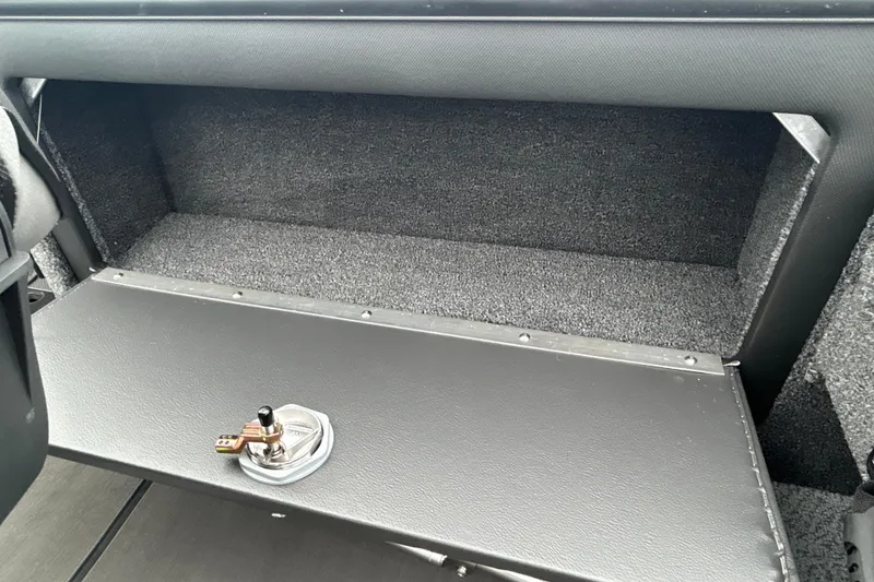 Slide: The Image of Interior storage compartment of 2026 Lund 1975 Pro-V boat, featuring a secure latch. - 27