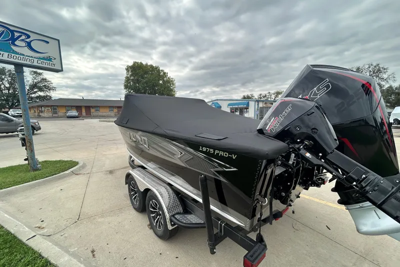 Slide: The Image of 2026 Lund 1975 Pro-V boat with cover, parked at a boating center. - 33