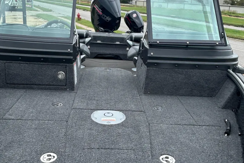 Slide: The Image of 2026 Lund 1975 Pro-V boat interior with carpeted deck and windshield view. - 7