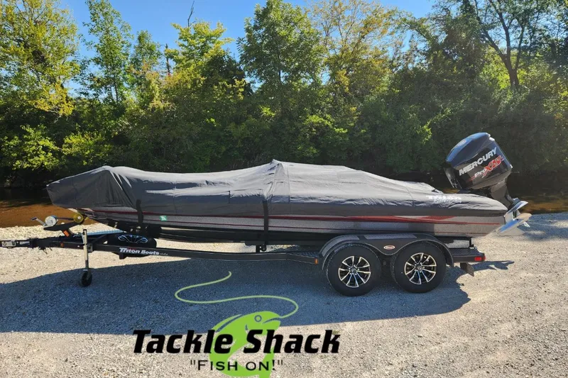 Slide: The Image of Covered 2013 Triton 19XS boat on trailer, parked outdoors near trees. - 1