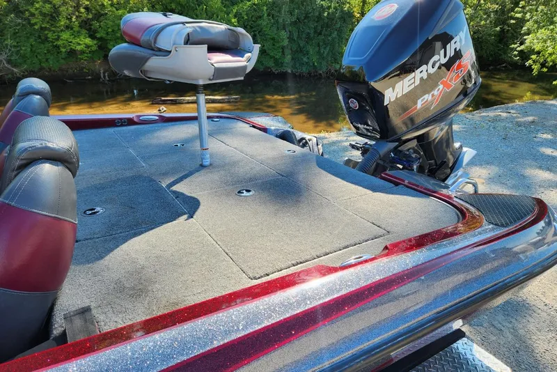 Slide: The Image of 2013 Triton 19XS boat with Mercury Pro XS engine, docked by a river. - 12