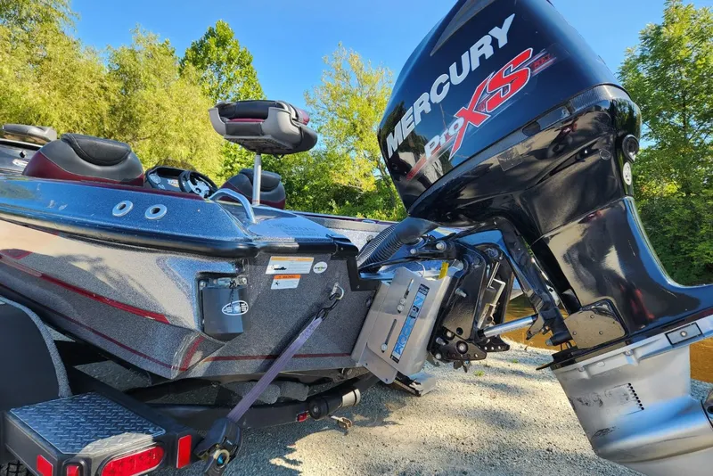Slide: The Image of 2013 Triton 19XS boat with Mercury Pro XS engine, parked on a gravel path. - 13