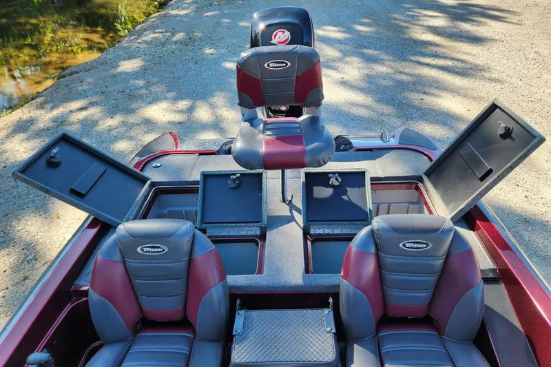 Slide: The Image of 2013 Triton 19XS boat interior with open storage compartments and seating. - 15