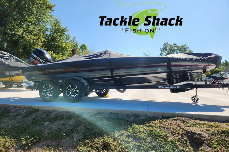 Slide: The Image of 2013 Triton 19XS boat with cover on trailer, Tackle Shack logo above. - 28