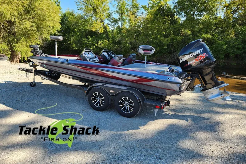 Slide: The Image of 2013 Triton 19XS boat with Mercury engine on trailer, parked near trees. - 4