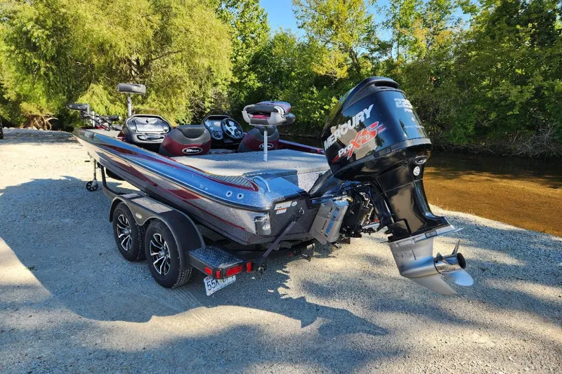 Slide: The Image of 2013 Triton 19XS boat with Mercury Pro XS engine, parked near a riverbank. - 5