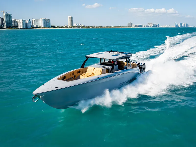 Slide: The Image of 2024 Concept 44' Open boat cruising on turquoise water near a city skyline. - 2