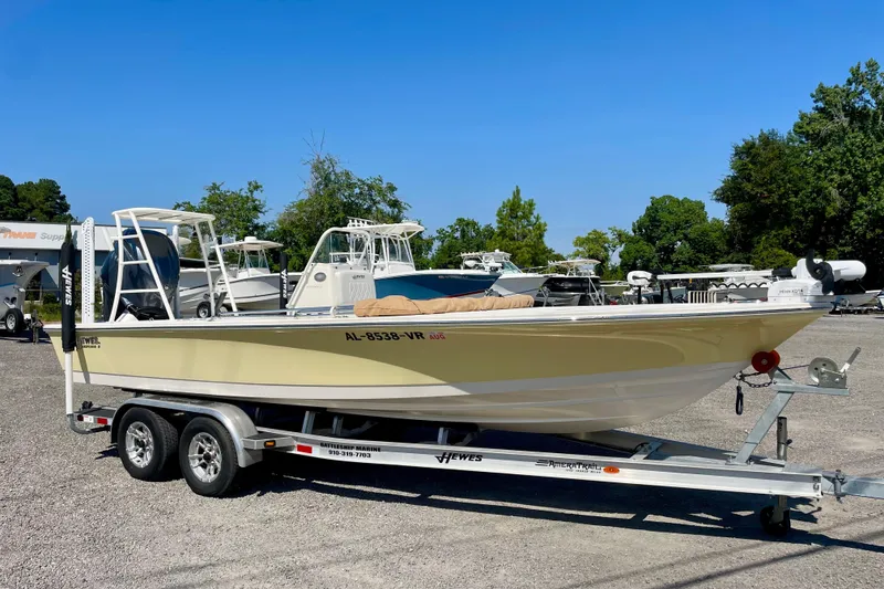 The Image of 2022 Hewes Redfisher 21 boat on trailer, parked outdoors under clear blue sky. - 0