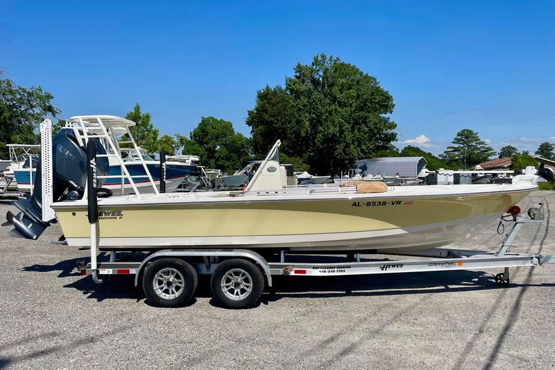 Slide: The Image of 2022 Hewes Redfisher 21 boat on trailer, parked outdoors under clear blue sky. - 1