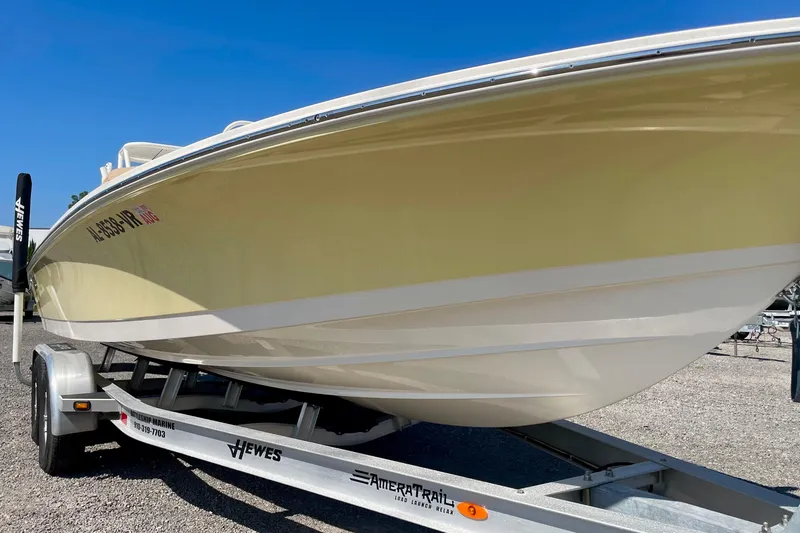 Slide: The Image of 2022 Hewes Redfisher 21 boat on trailer, side view under clear blue sky. - 11