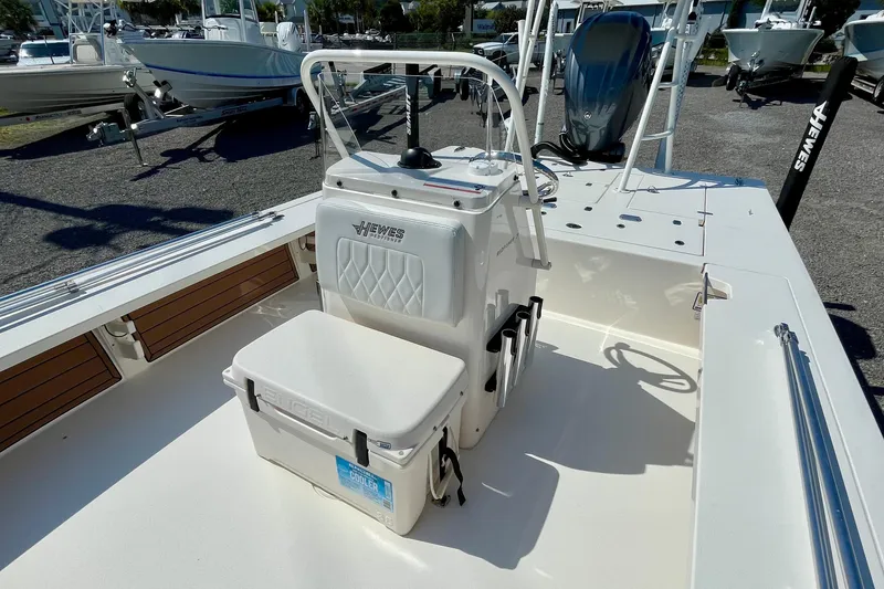Slide: The Image of 2022 Hewes Redfisher 21 boat interior with console and seating, parked outdoors. - 17