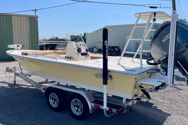 Slide: The Image of 2022 Hewes Redfisher 21 boat on trailer, parked outdoors near industrial buildings. - 7