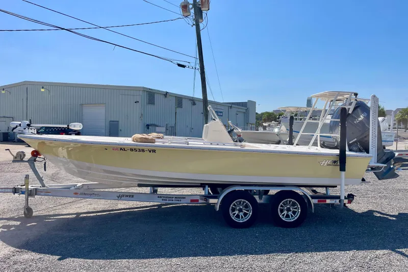 Slide: The Image of 2022 Hewes Redfisher 21 boat on trailer, parked outdoors under clear blue sky. - 8
