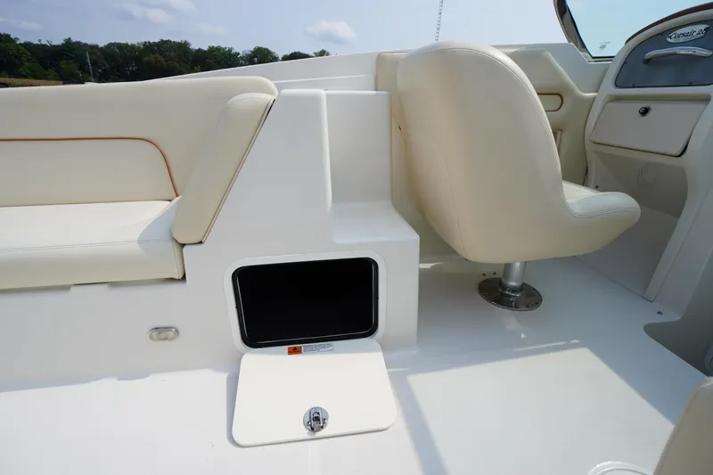 Slide: The Image of 2007 Chris-Craft Corsair 28 interior with beige seating and storage compartment. - 13