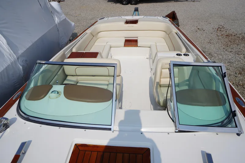 Slide: The Image of 2007 Chris-Craft Corsair 28 boat interior with beige seating and open windshield. - 3