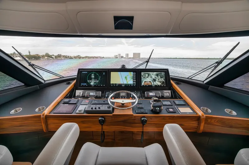 Slide: The Image of 2024 Viking 72 Skybridge yacht helm with advanced navigation systems and panoramic water view. - 25