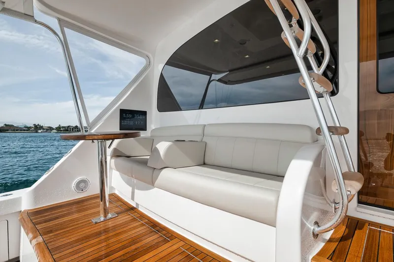Slide: The Image of 2024 Viking 72 Skybridge yacht with elegant seating and wooden deck. - 48