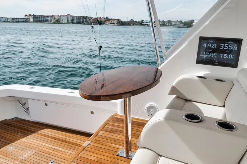 Slide: The Image of Luxurious 2024 Viking 72 Skybridge yacht interior with wooden deck and seating area. - 49