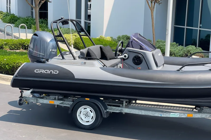 Slide: The Image of 2017 Grand Goldenline 500 boat on trailer, parked outdoors with Yamaha 130 engine. - 11