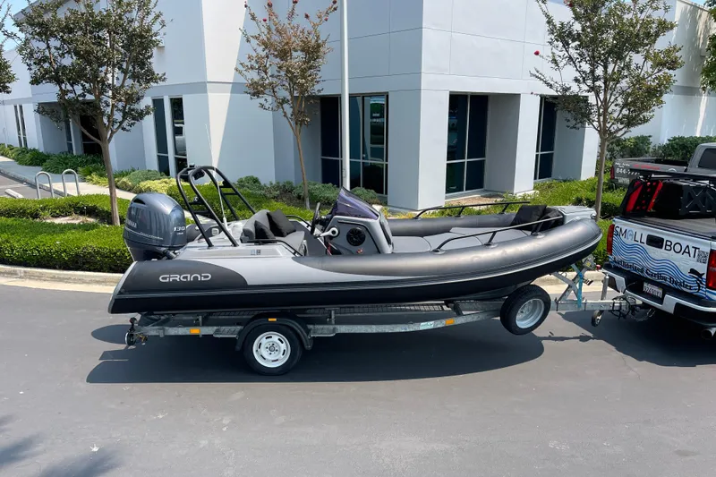 Slide: The Image of 2017 Grand Goldenline 500 boat on trailer, parked near modern building. - 12